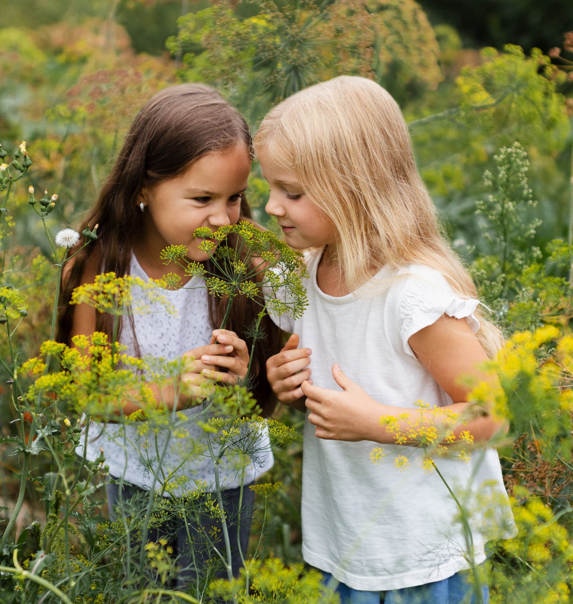 Two girls smelling flowers