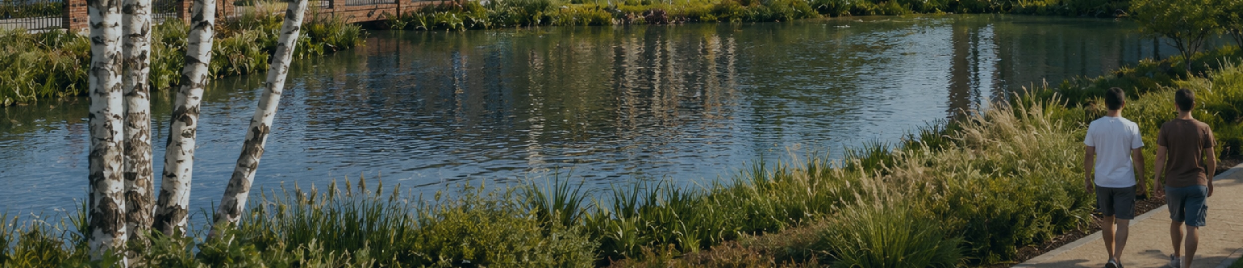 Two people walking next to a river