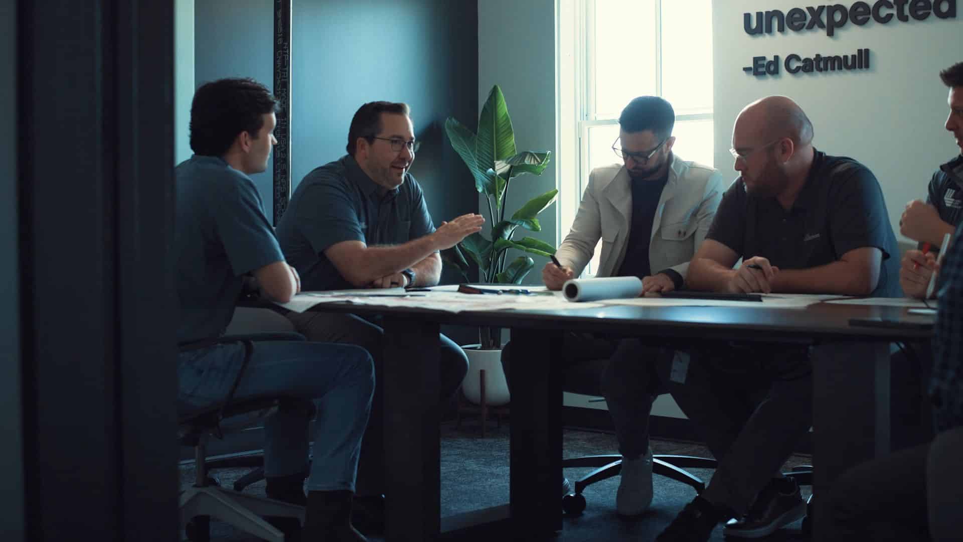 A group of friends looking over blueprints